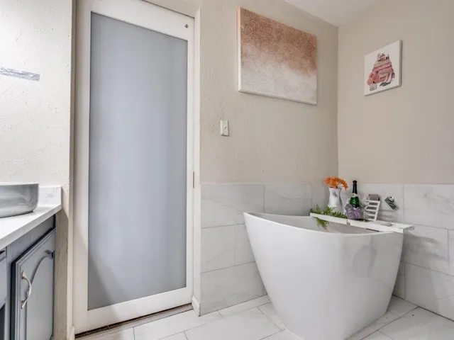 a bathroom with a sink a toilet a mirror and shower