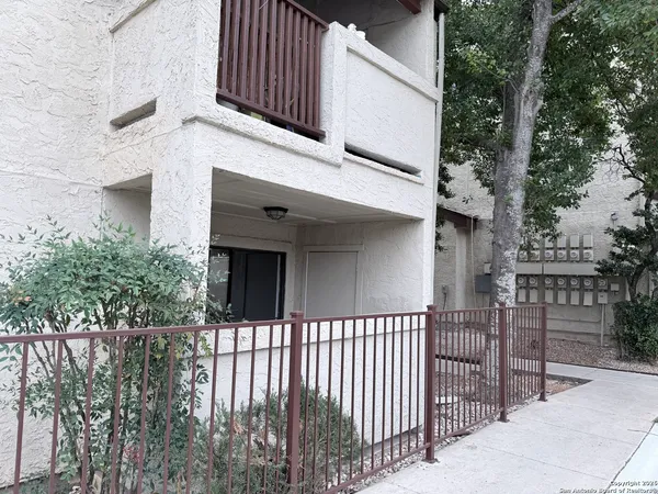 a view of a house with a small yard and wooden fence