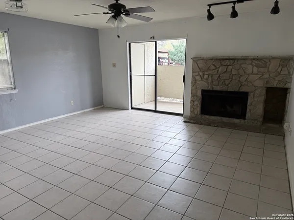 an empty room with windows and a fireplace