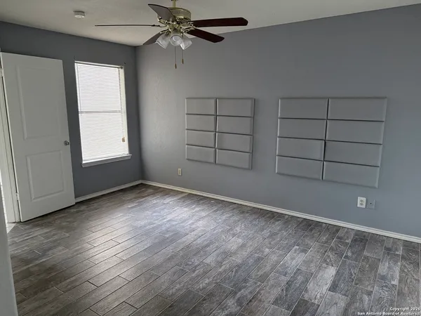 an empty room with cabinet and windows