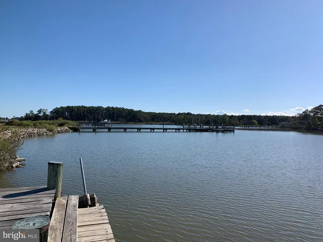 a wooden pier with boats in a lake