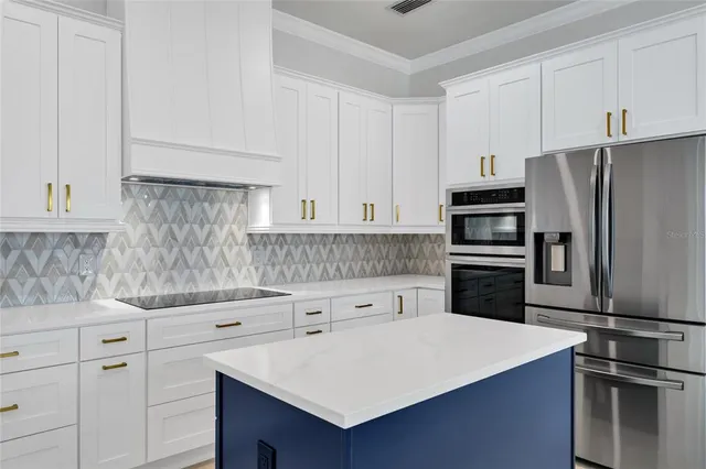 a kitchen with granite countertop white cabinets and stainless steel appliances