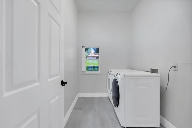 a view of a house next to a big yard and large trees
