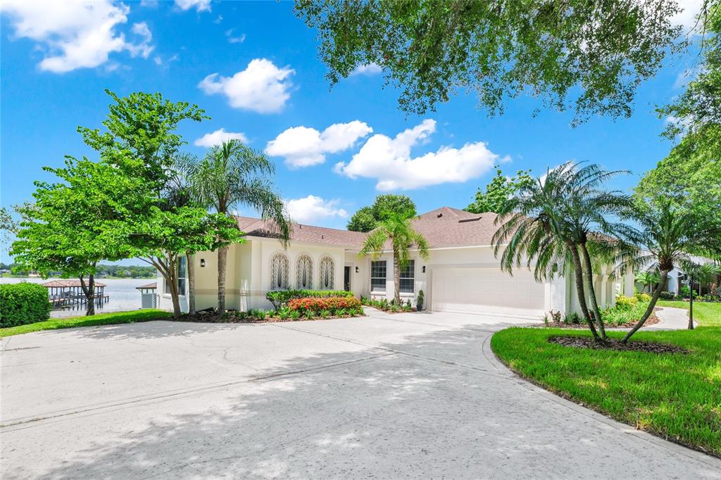 1703 Roberts Landing Road Windermere, FL 34786 - Photo 46 of 61 a view of a house with palm trees and a small yard