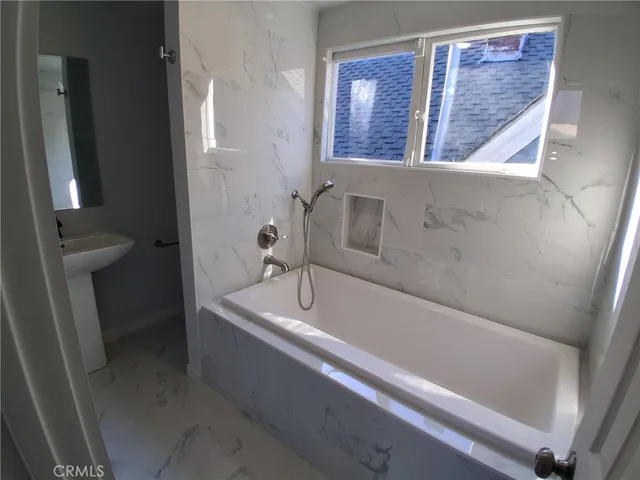 a bath tub sitting next to a white sink