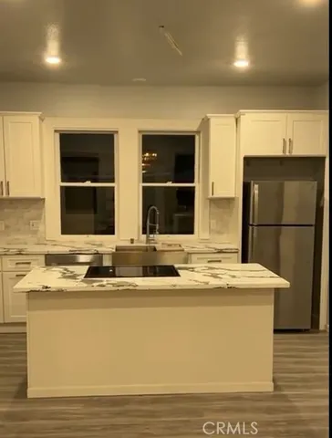 a kitchen with stainless steel appliances granite countertop a sink and a refrigerator