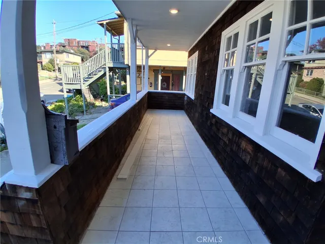 a view of a house with a large tree and wooden fence