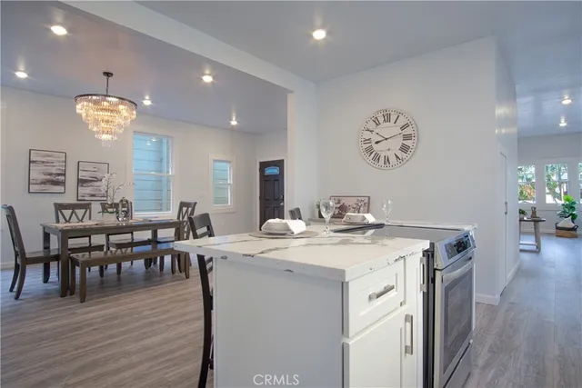 a kitchen that has a lot of cabinets a sink and wooden floor