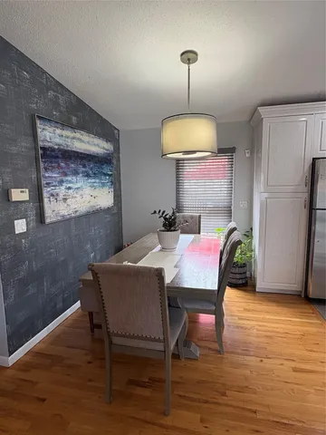 a dining room with furniture a chandelier and wooden floor