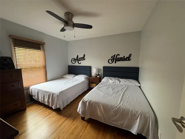 a bedroom with two beds and painting on the wall