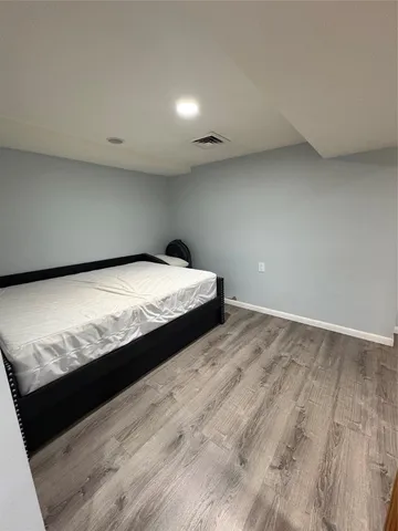 a bedroom with a bed and a wooden floor