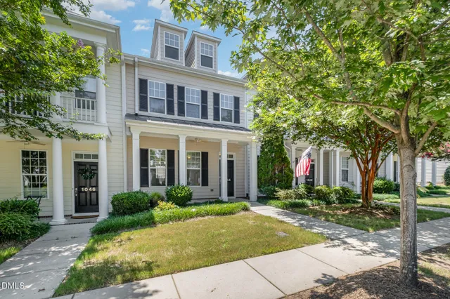 a front view of multiple houses with yard