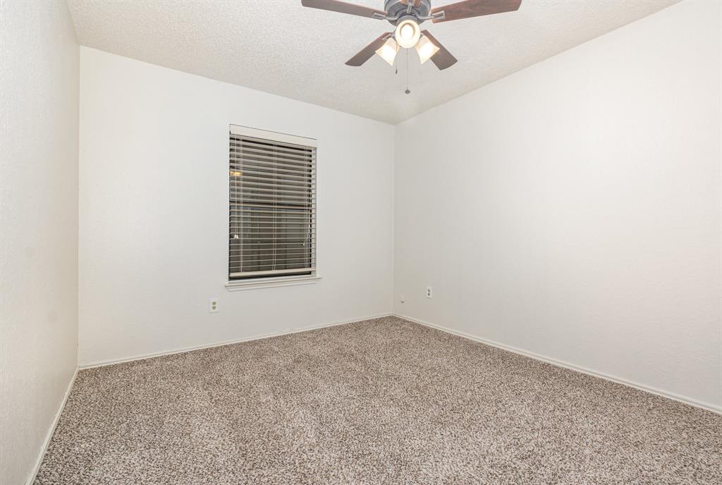 1046 Colony Street Flower Mound, TX 75028 - Photo 15 of 19 an empty room with a chandelier fan and windows