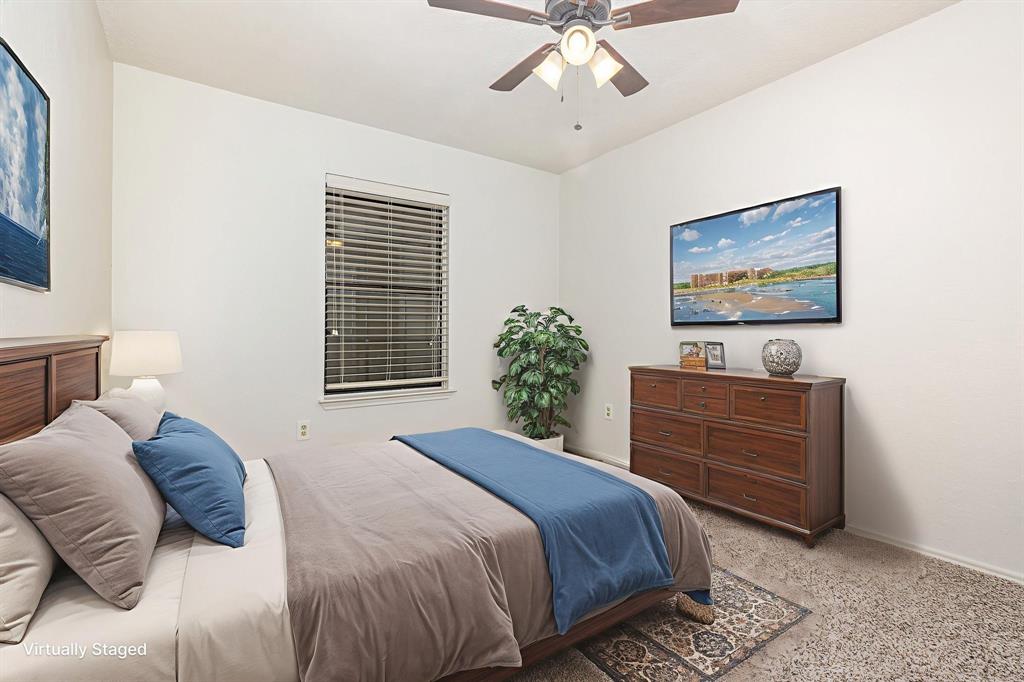 1046 Colony Street Flower Mound, TX 75028 - Photo 17 of 21 a bedroom with a bed and a chandelier