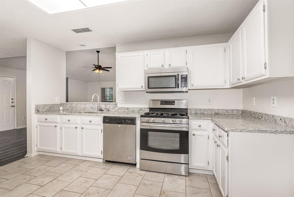 1046 Colony Street Flower Mound, TX 75028 - Photo 8 of 19 a kitchen with cabinets stainless steel appliances and sink