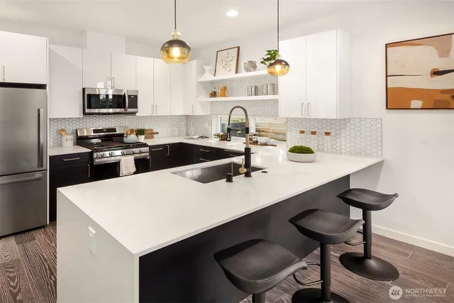 a kitchen with a sink a stove and chairs