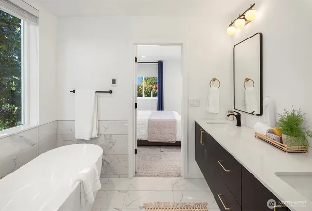 a bathroom with a tub sink and mirror