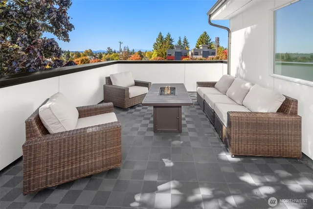 a view of roof deck with couches and sky view