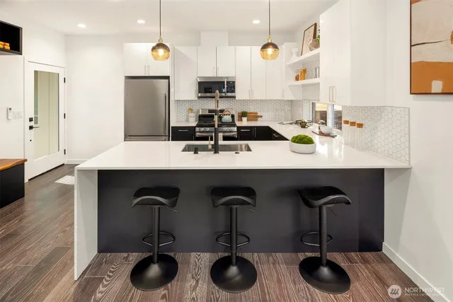 a kitchen with sink a refrigerator and chairs