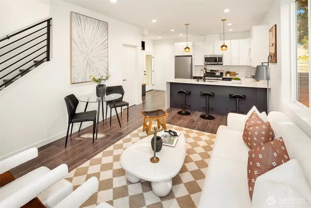 a living room with stainless steel appliances kitchen island granite countertop a dining table chairs and a coffee table