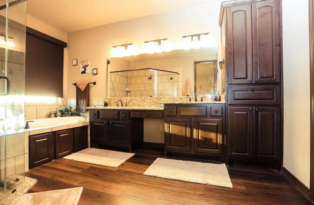 667 Comanche Lake Road Comanche, TX 76442 - Photo 13 of 26 a spacious bathroom with a granite countertop sink and a mirror