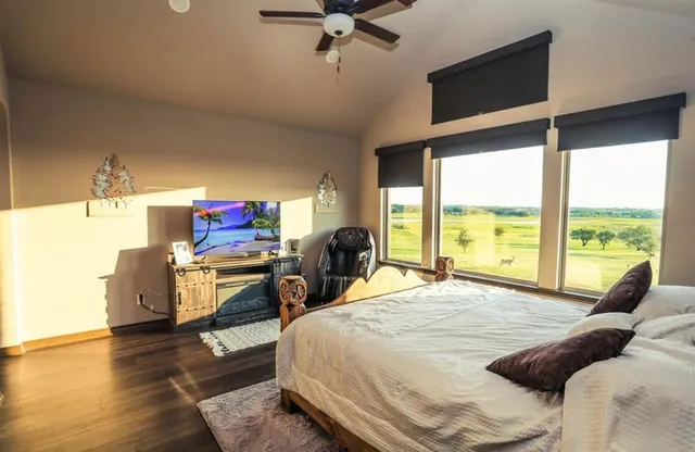 a living room with furniture a flat screen tv and a large window