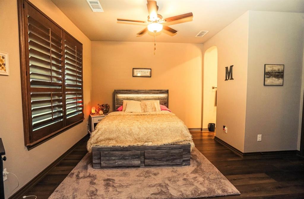 667 Comanche Lake Road Comanche, TX 76442 - Photo 22 of 26 a bedroom with a bed and wooden floor