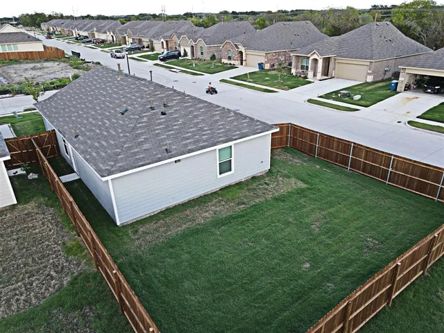 an aerial view of residential houses with yard