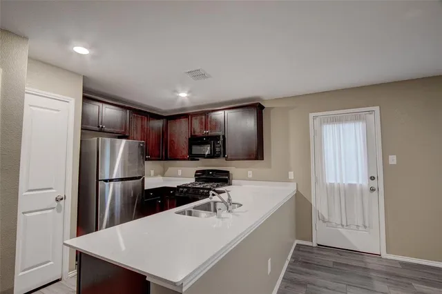 a kitchen with refrigerator cabinets and wooden floor