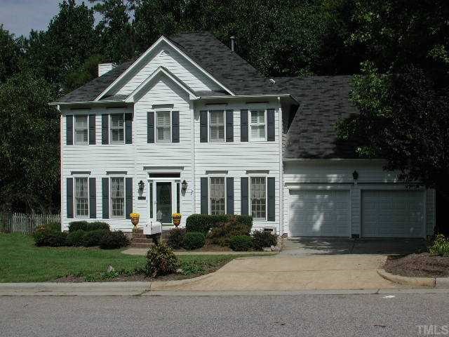 a front view of a house with a garden and garage