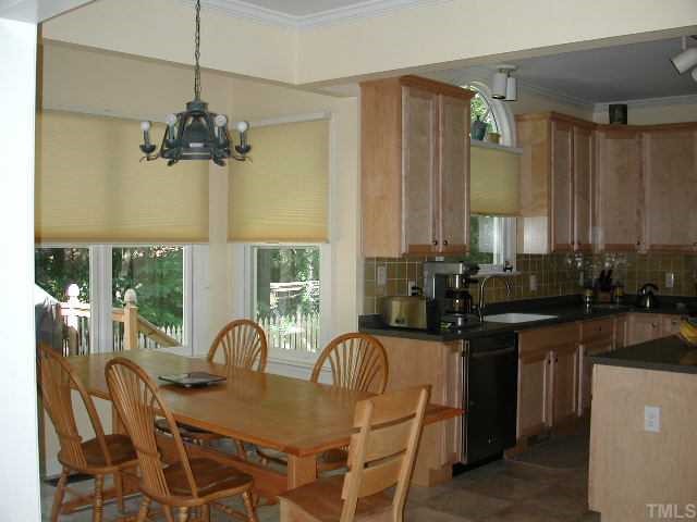 4412 Queenstown Court Raleigh, NC 27612 - Photo 4 of 11 a kitchen with a table chairs stove and cabinets