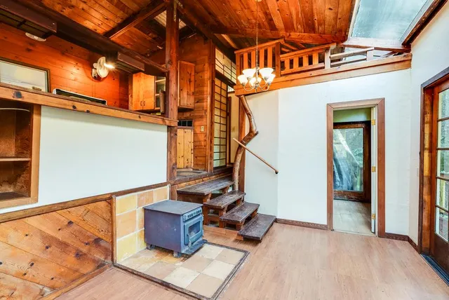 a view of an empty room with wooden floor and windows
