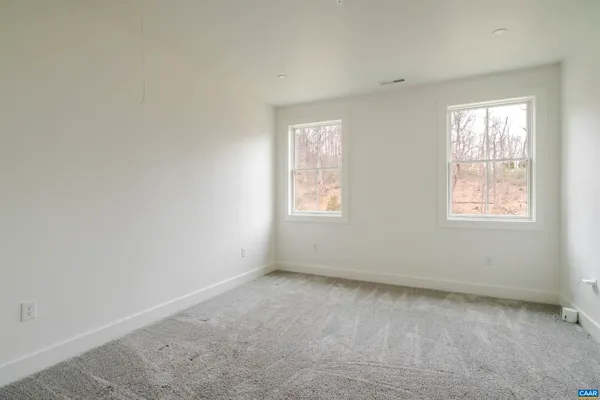 a view of an empty room with wooden floor and closet