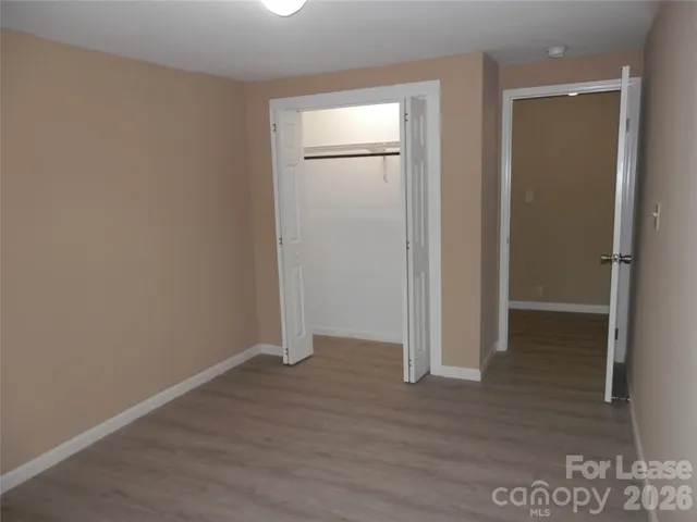 an empty room with wooden floor and closet