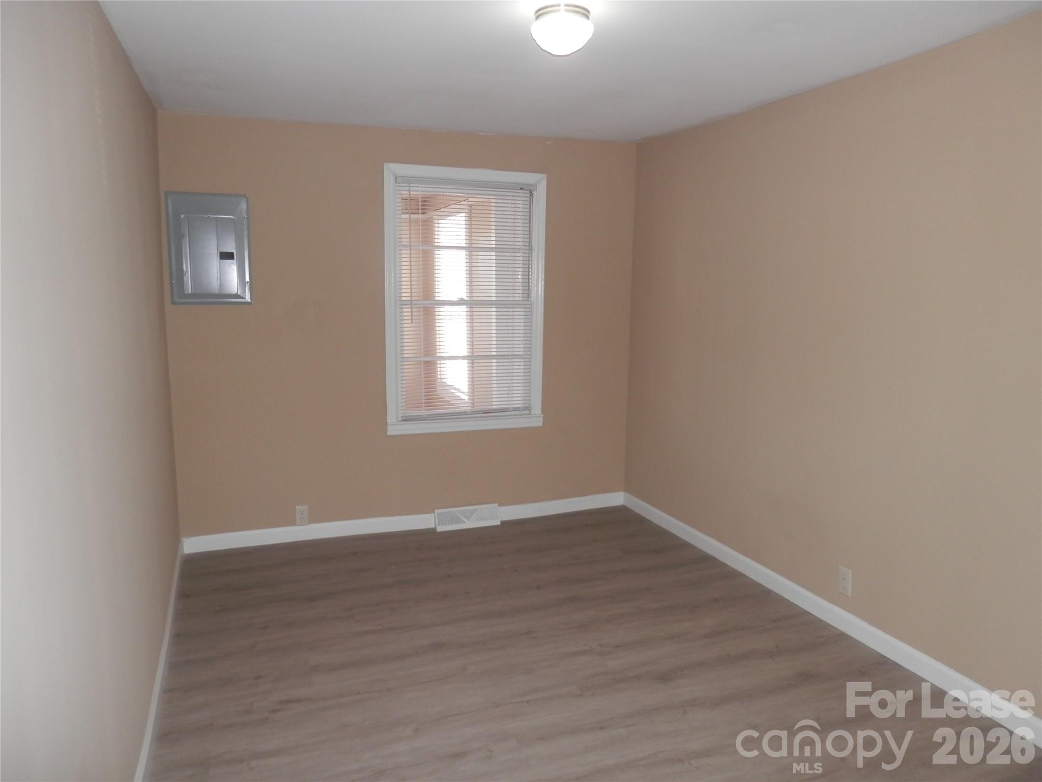 67 Barber Street Northwest Concord, NC 28027 - Photo 13 of 27 an empty room with wooden floor and windows