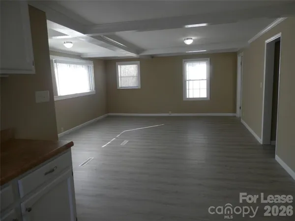 a kitchen with granite countertop white cabinets stainless steel appliances and a window