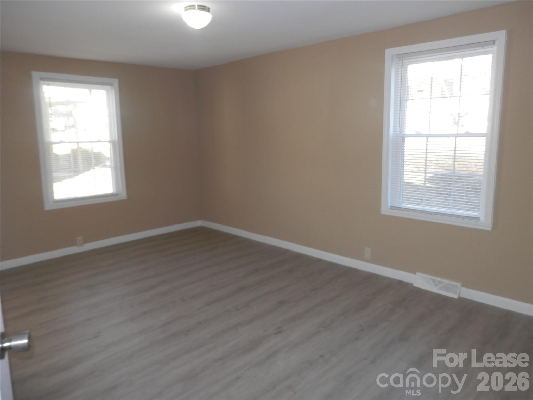 67 Barber Street Northwest Concord, NC 28027 - Photo 7 of 27 an empty room with wooden floor and windows