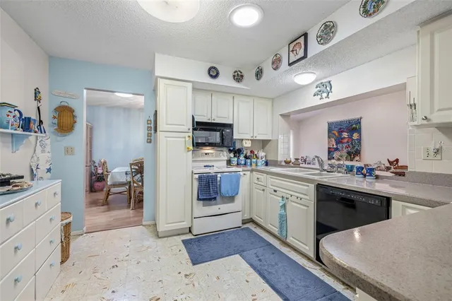 a kitchen with cabinets a sink and appliances