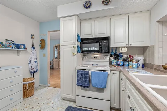 a kitchen with a refrigerator and a stove top oven