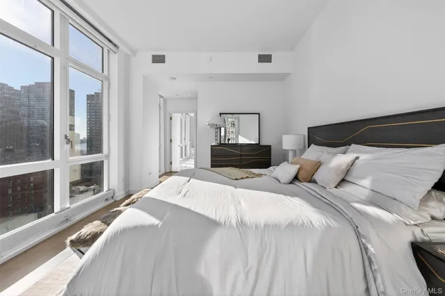 a bedroom with a bed and a large window