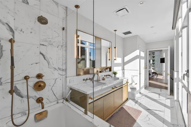 a bathroom with a tub sink mirror and shower
