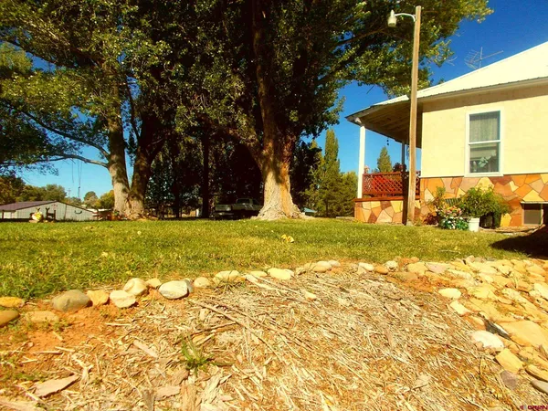 a front view of a house with a garden and trees