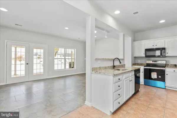 a kitchen with stainless steel appliances granite countertop a stove a sink and a microwave