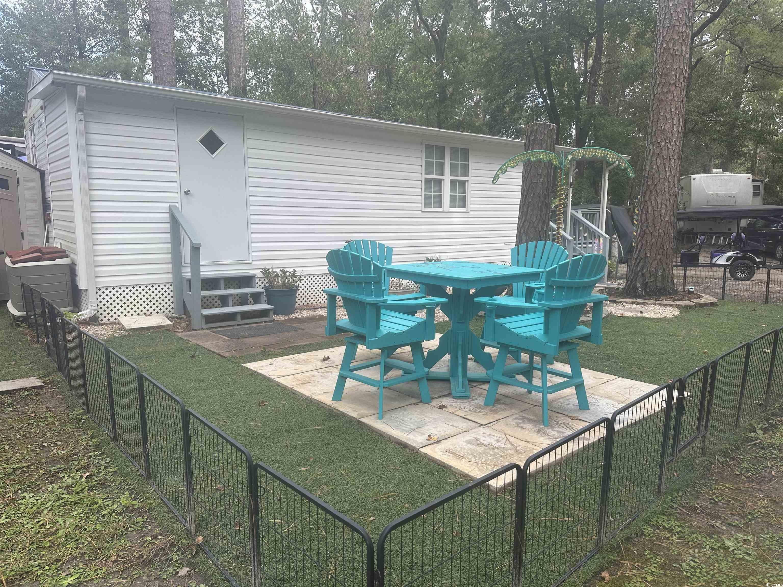 613-431 5th Avenue South Myrtle Beach, SC 29577 - Photo 24 of 36 Rear view of property featuring entry steps, a fenced backyard, a patio area, and view of scattered trees