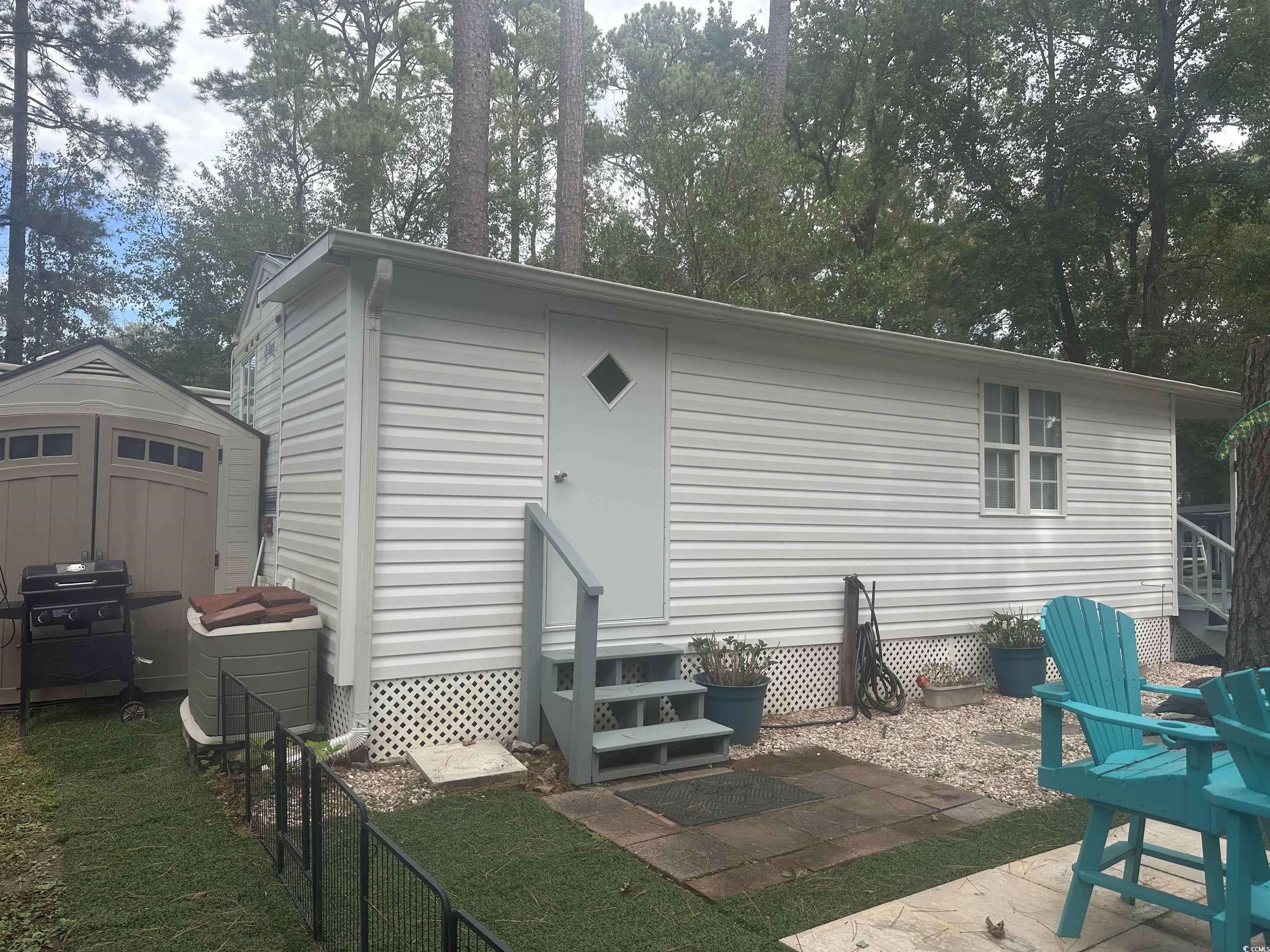 613-431 5th Avenue South Myrtle Beach, SC 29577 - Photo 25 of 36 Back of house featuring entry steps, a patio, a storage shed, and a lawn