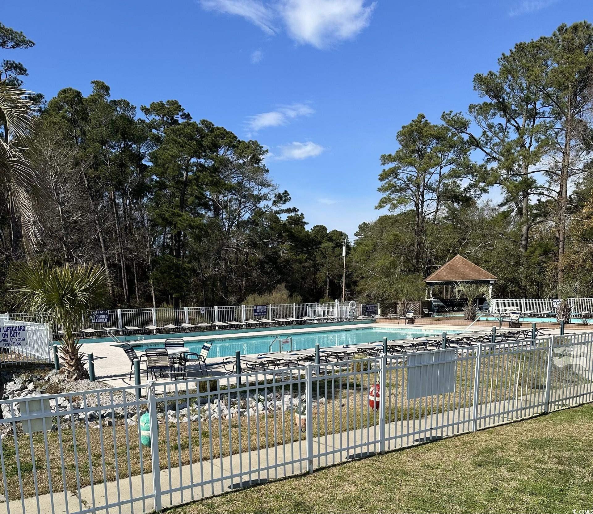 613-431 5th Avenue South Myrtle Beach, SC 29577 - Photo 30 of 36 Community pool with view of wooded area, a patio area, and a gazebo