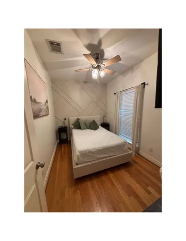 a living room with a bed furniture and a ceiling fan