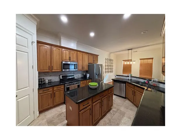 a kitchen with stainless steel appliances granite countertop a stove a sink dishwasher and a refrigerator
