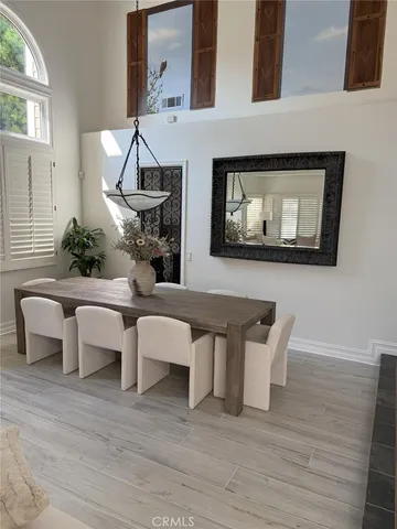 a living room with couches chairs and kitchen view with wooden floor