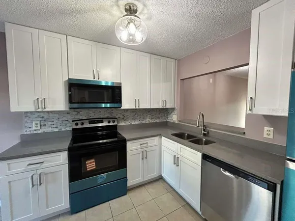 a kitchen with a sink stove and microwave